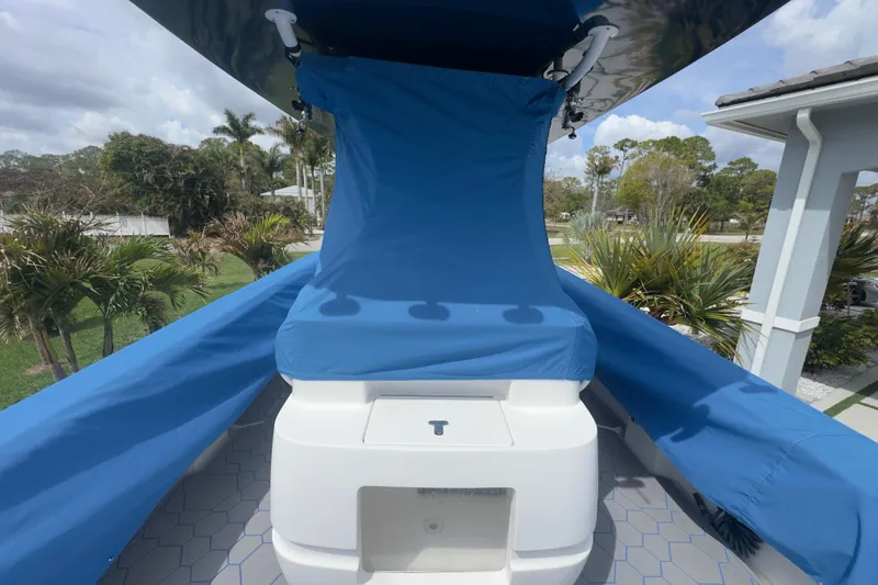 Slide: The Image of 2007 Intrepid 370 Center Console with blue protective cover, surrounded by tropical greenery. - 100