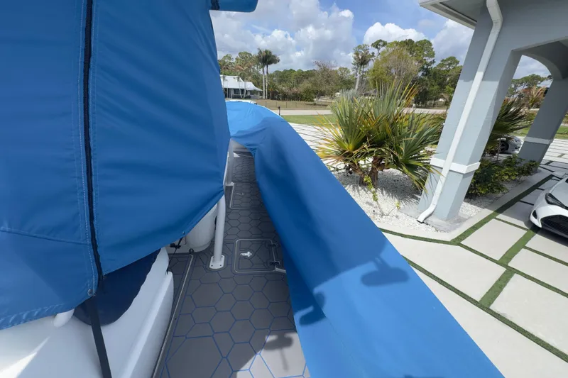 Slide: The Image of Covered 2007 Intrepid 370 Center Console boat parked near a modern driveway. - 103