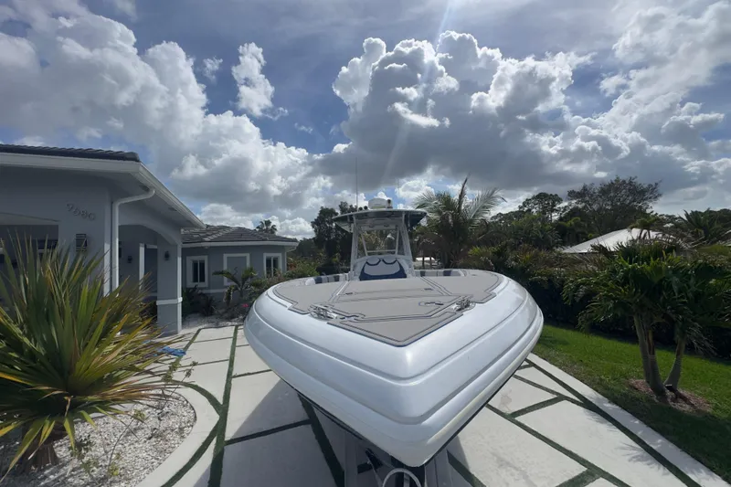 Slide: The Image of 2007 Intrepid 370 Center Console boat parked in a residential driveway under cloudy sky. - 26