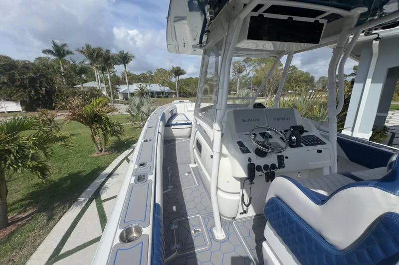 Slide: The Image of 2007 Intrepid 370 Center Console boat with Garmin navigation, docked near palm trees. - 37