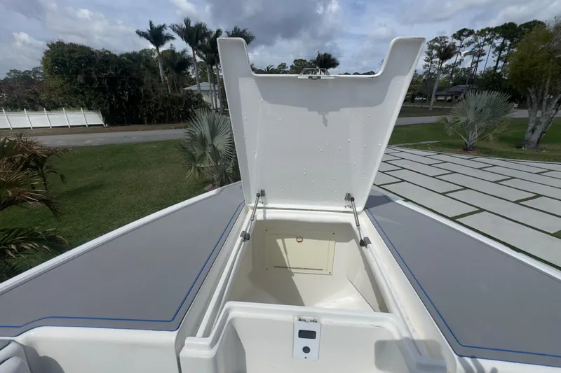 Slide: The Image of Open storage compartment on 2007 Intrepid 370 Center Console boat, surrounded by greenery. - 50