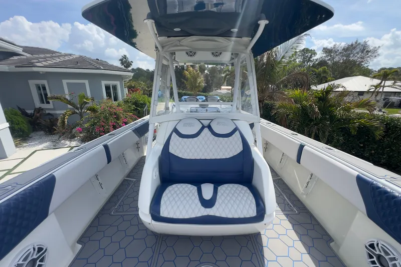 Slide: The Image of 2007 Intrepid 370 Center Console boat with blue and white seating, docked near a house. - 58