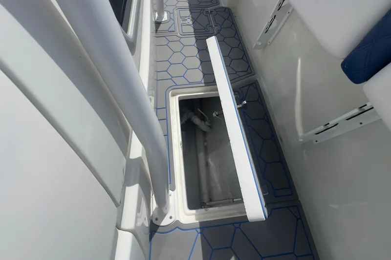 Slide: The Image of 2007 Intrepid 370 Center Console boat storage compartment with open hatch and hexagonal floor pattern. - 62
