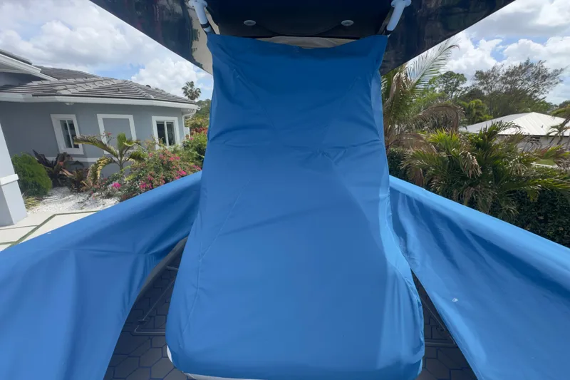 Slide: The Image of Blue cover on 2007 Intrepid 370 Center Console boat, surrounded by tropical foliage. - 99