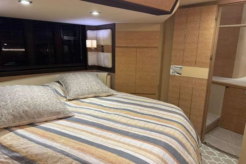 Slide: The Image of Luxurious bedroom interior of 2014 Azimut 64 yacht with blue bedding and decorative pillows. - 24