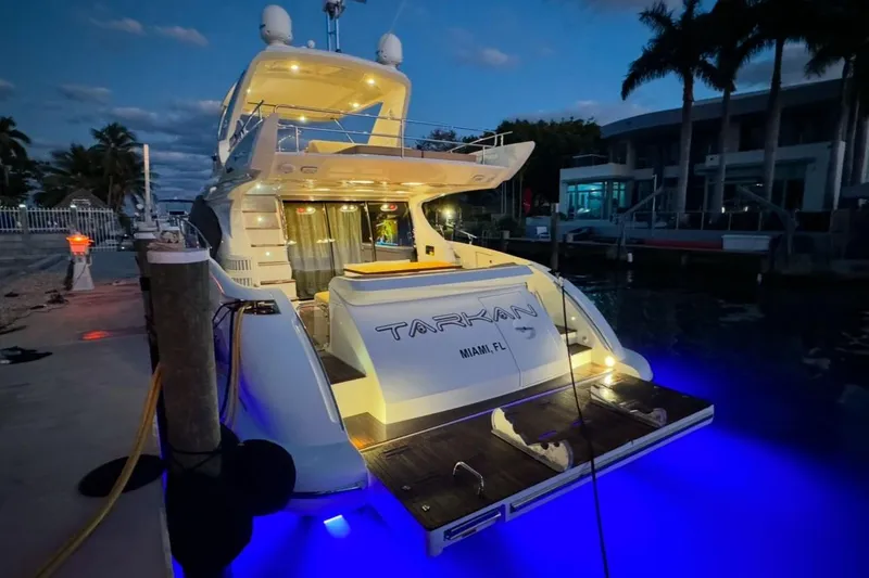 Slide: The Image of Luxurious 2014 Azimut 64 yacht docked at night, illuminated by red lights. - 3