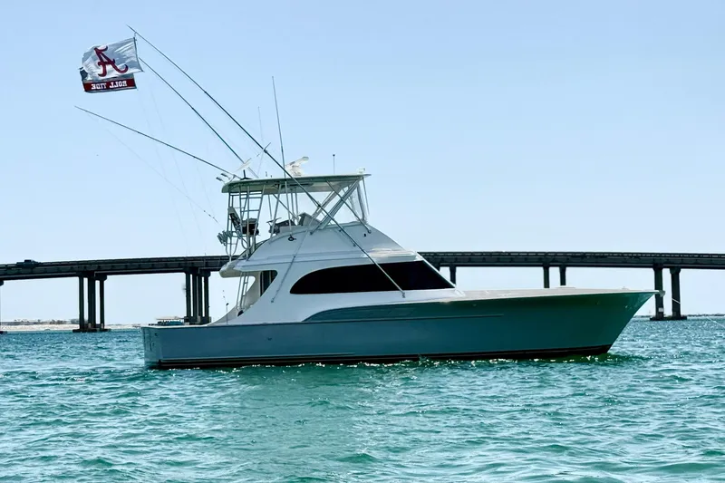 Slide: The Image of 1988 Buddy Davis 47 Convertible yacht on water, bridge in background, clear sky. - 1