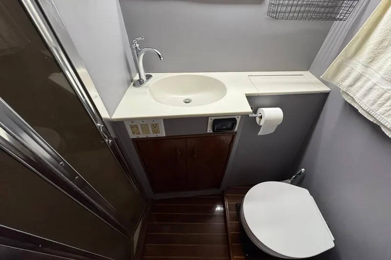 Slide: The Image of Bathroom interior of 1988 Buddy Davis 47 Convertible yacht, featuring sink and toilet. - 31