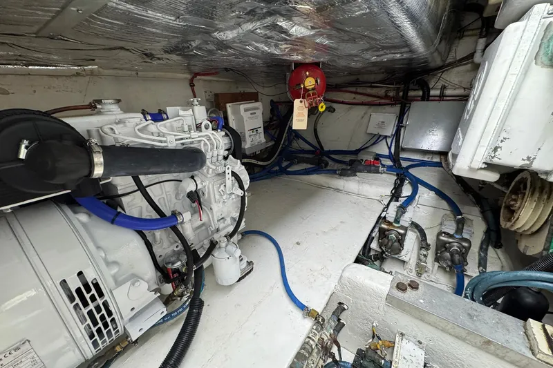 Slide: The Image of Engine room of a 1988 Buddy Davis 47 Convertible boat, showcasing mechanical components. - 38
