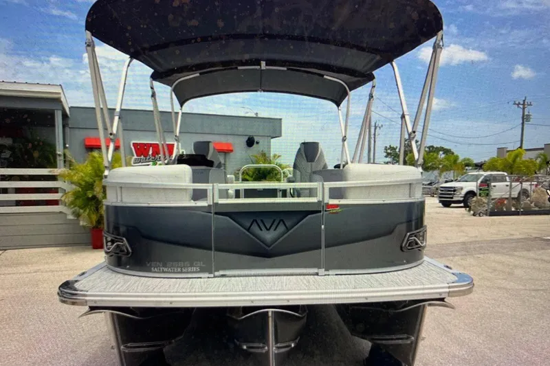 Slide: The Image of 2025 Avalon 2585 Venture Quad Lounge pontoon boat, rear view, in a dealership lot. - 2