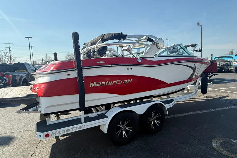 Slide: The Image of 2013 MasterCraft X10 boat on trailer, red and white design, parked outdoors. - 4