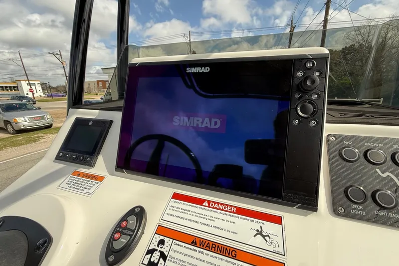Slide: The Image of 2025 Shallow Sport boat dashboard with Simrad display and control panel. - 16