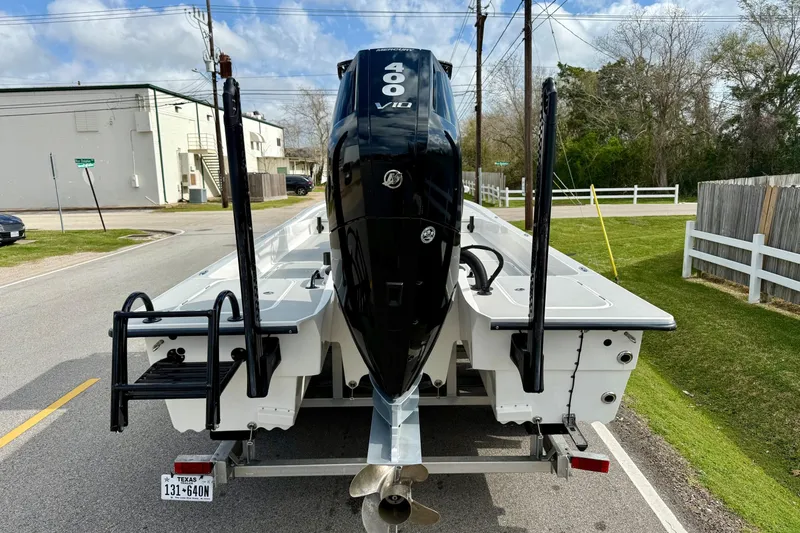 Slide: The Image of 2025 Shallow Sport boat with powerful 400 V10 engine on trailer, parked on street. - 3