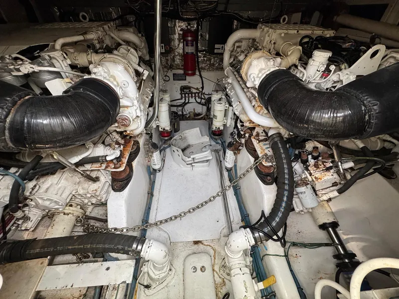 Slide: The Image of Engine room of a 1999 Cabo 45 Express boat, featuring dual engines and mechanical components. - 11