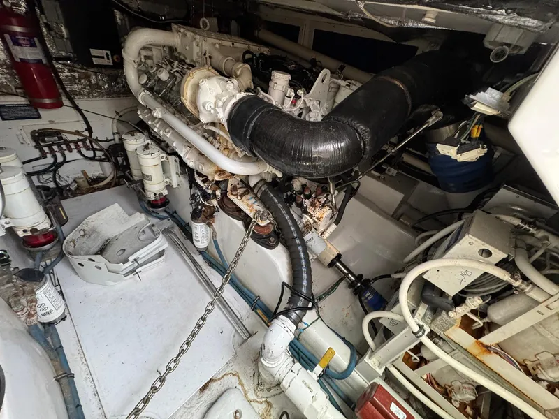 Slide: The Image of Engine room of a 1999 Cabo 45 Express boat, showcasing mechanical components and piping. - 12
