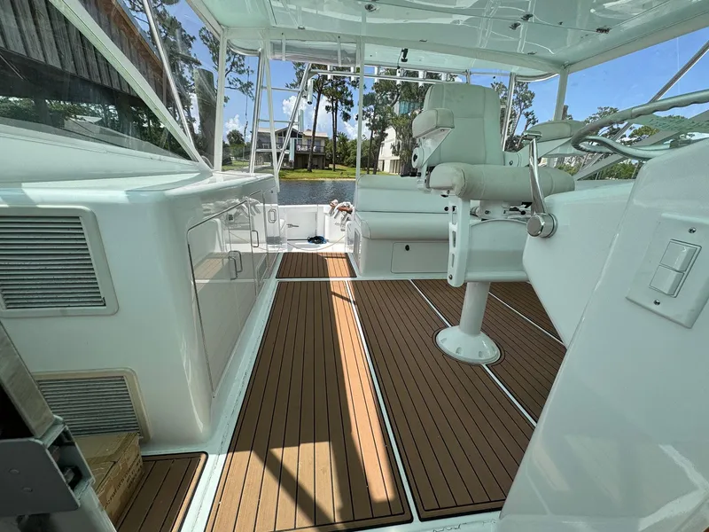 Slide: The Image of 1999 Cabo 45 Express boat interior with wooden flooring and white seating. - 4