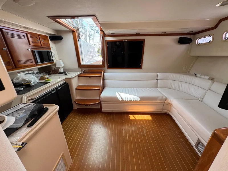 Slide: The Image of Interior of 1999 Cabo 45 Express yacht with white seating and wooden flooring. - 6