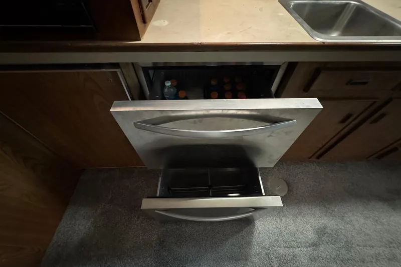 Slide: The Image of 1979 Bertram 38 Convertible kitchen with open drawers and visible storage. - 18