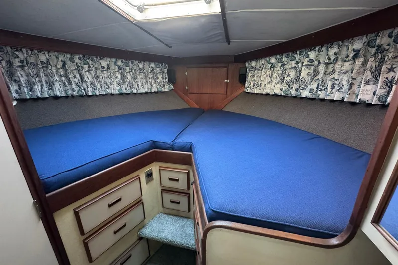 Slide: The Image of 1979 Bertram 38 Convertible cabin with blue bedding and floral curtains. - 24