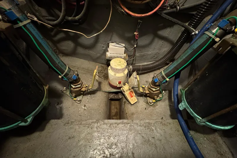 Slide: The Image of Engine room of a 1979 Bertram 38 Convertible with visible pipes and wiring. - 30