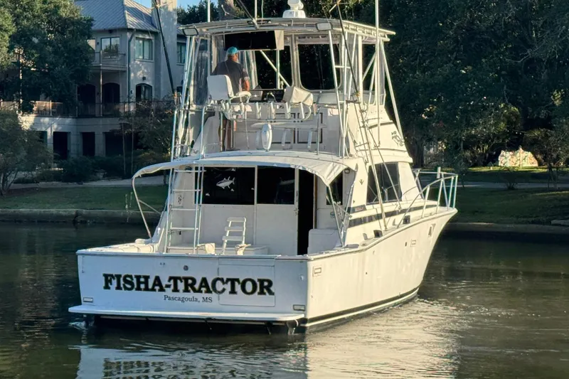 Slide: The Image of 1979 Bertram 38 Convertible boat named "FISHA-TRACTOR" in a serene waterway setting. - 4