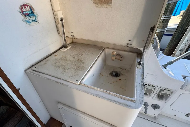 Slide: The Image of 1979 Bertram 38 Convertible boat sink area with storage and faucet. - 9