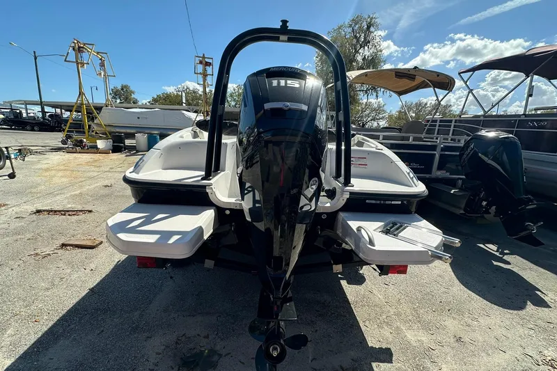 Slide: The Image of 2026 Bayliner Element E18 boat with outboard motor, parked outdoors under a clear sky. - 17