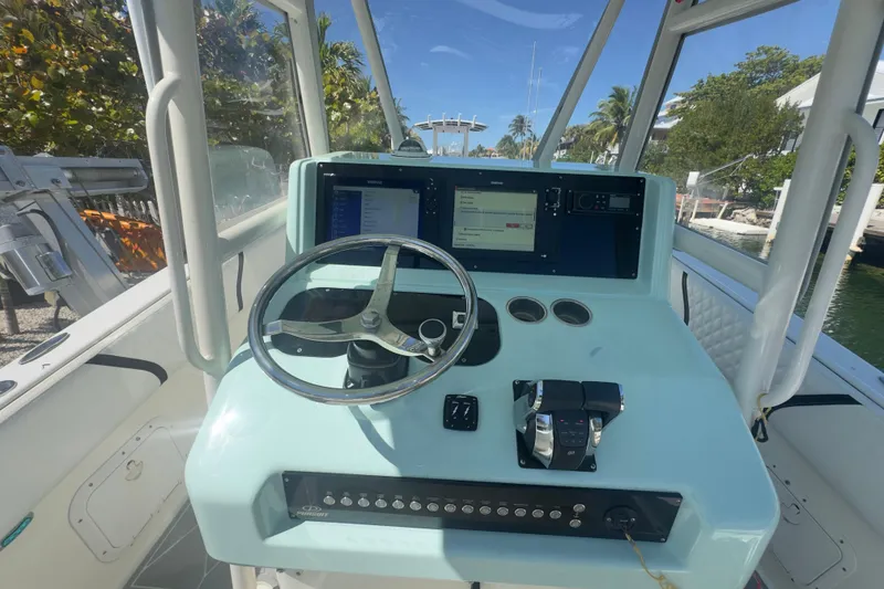 Slide: The Image of 2000 Pursuit 2870 Center Console boat dashboard with steering wheel and navigation screens. - 12