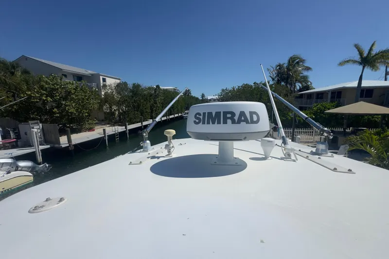 Slide: The Image of 2000 Pursuit 2870 Center Console boat with Simrad radar, docked near waterfront homes. - 17