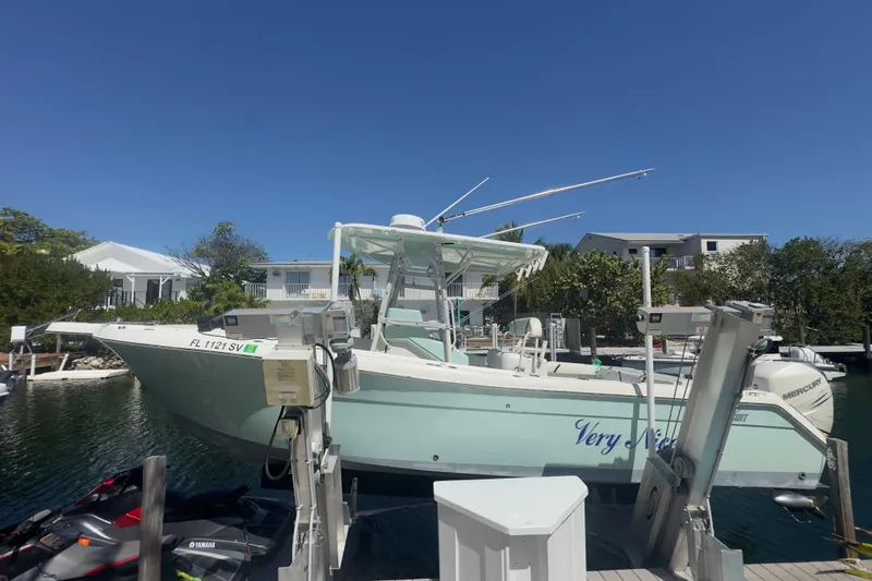 Slide: The Image of 2000 Pursuit 2870 Center Console boat docked at marina under clear blue sky. - 2