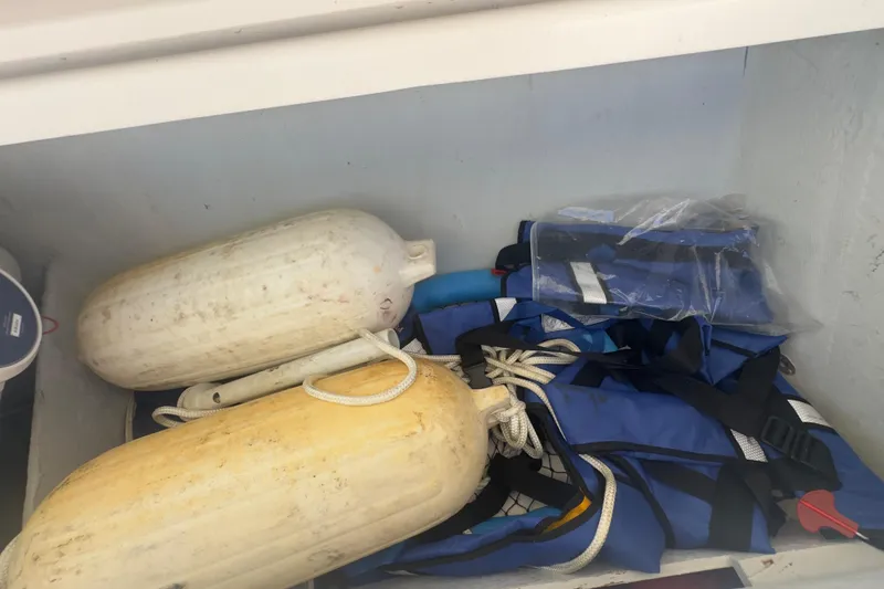 Slide: The Image of Storage compartment with boat fenders and life jackets on a 2000 Pursuit 2870 Center Console. - 23