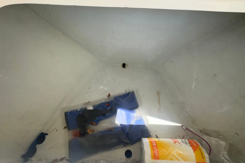 Slide: The Image of Storage compartment of a 2000 Pursuit 2870 Center Console boat with miscellaneous items. - 24