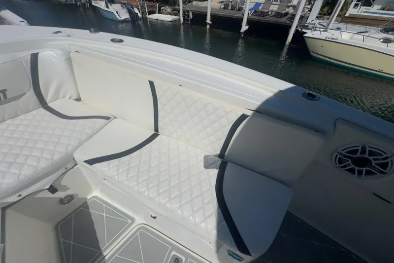 Slide: The Image of 2000 Pursuit 2870 Center Console boat with white cushioned seating and waterfront view. - 25
