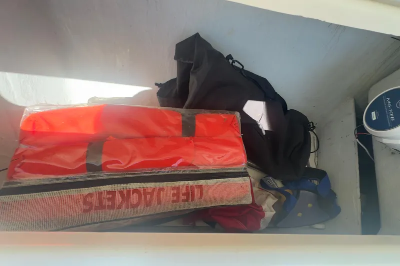 Slide: The Image of Storage compartment on a 2000 Pursuit 2870 Center Console with life jackets and gear. - 26