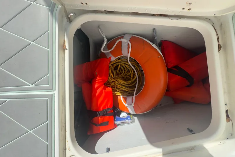 Slide: The Image of Storage compartment on 2000 Pursuit 2870 Center Console with life jackets and lifebuoy. - 27