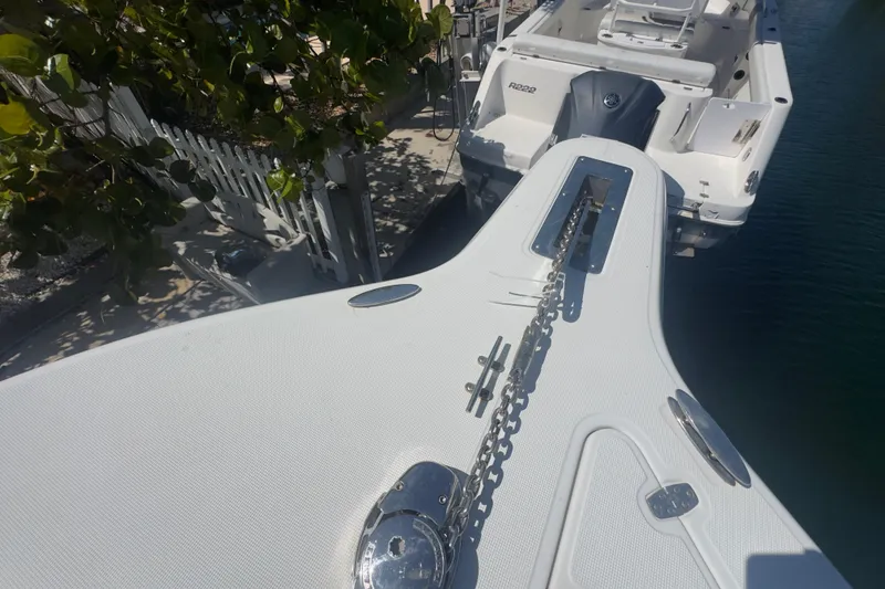 Slide: The Image of Bow of a 2000 Pursuit 2870 Center Console boat docked near a leafy shoreline. - 32