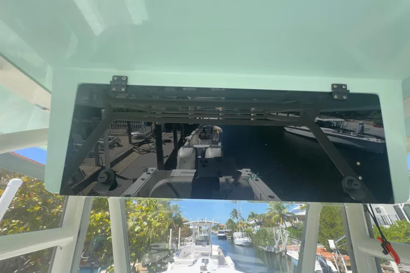 Slide: The Image of 2000 Pursuit 2870 Center Console boat with reflective panel, docked near palm trees. - 4