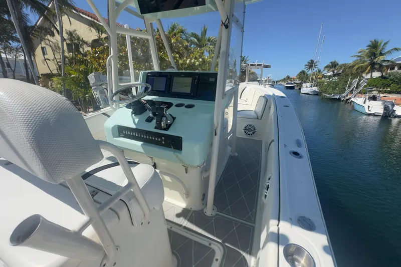 Slide: The Image of 2000 Pursuit 2870 Center Console boat on a sunny canal, featuring helm and seating. - 41