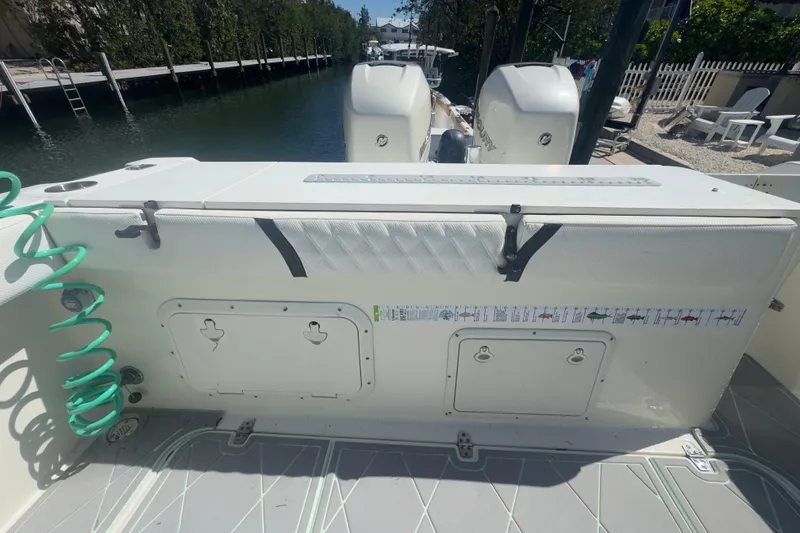 Slide: The Image of 2000 Pursuit 2870 Center Console boat interior with storage compartments and green hose. - 47