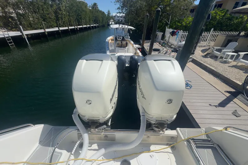 Slide: The Image of 2000 Pursuit 2870 Center Console boat with dual outboard engines docked in a canal. - 51