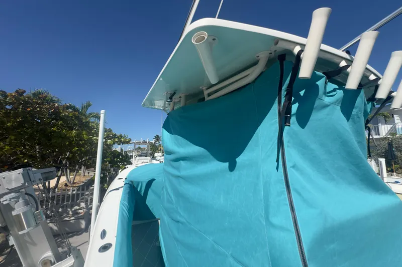 Slide: The Image of 2000 Pursuit 2870 Center Console boat with turquoise cover under clear blue sky. - 54