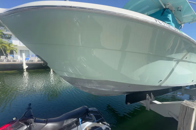 Slide: The Image of 2000 Pursuit 2870 Center Console boat on lift, near water and dock. - 58