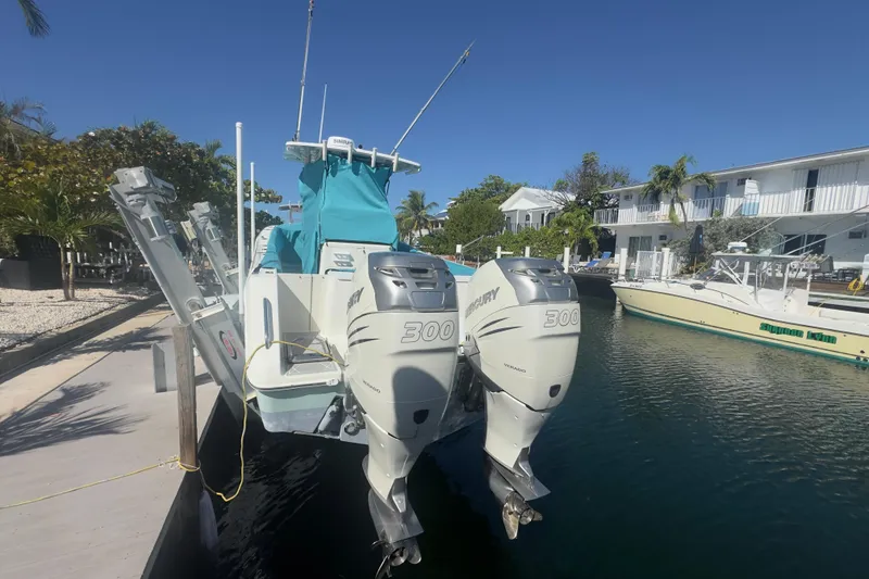 Slide: The Image of 2000 Pursuit 2870 Center Console boat with dual Mercury 300 engines docked by waterfront homes. - 62
