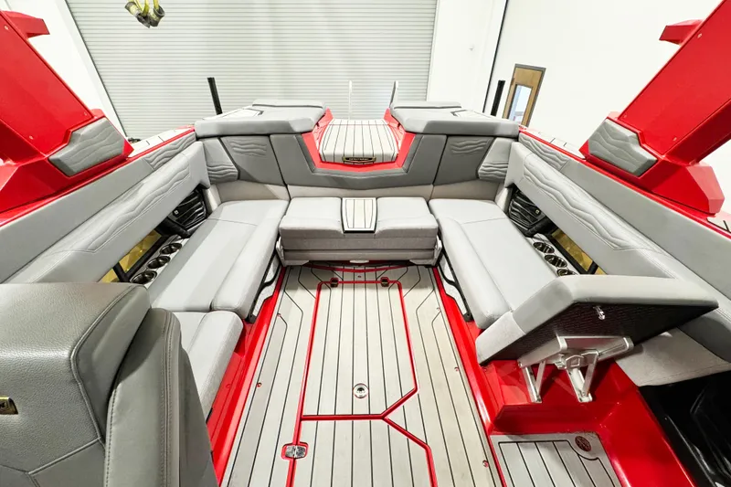 Slide: The Image of 2025 Nautique Super Air Nautique G23 Coastal Edition interior with red and gray seating. - 10
