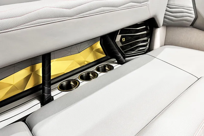 Slide: The Image of 2025 Nautique Super Air Nautique G23 Coastal Edition interior with cup holders and speaker. - 13