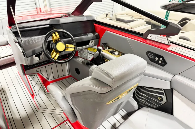 Slide: The Image of 2025 Nautique Super Air Nautique G23 Coastal Edition interior with modern helm and gold accents. - 19