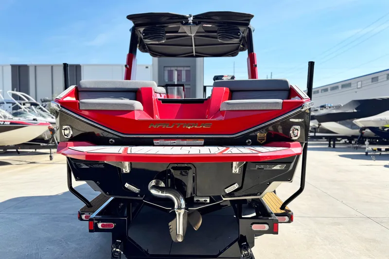 Slide: The Image of 2025 Nautique Super Air Nautique G23 Coastal Edition, rear view, vibrant red and black design. - 4