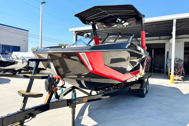 Slide: The Image of 2025 Nautique Super Air Nautique G23 Coastal Edition boat on trailer, black and red design. - 5