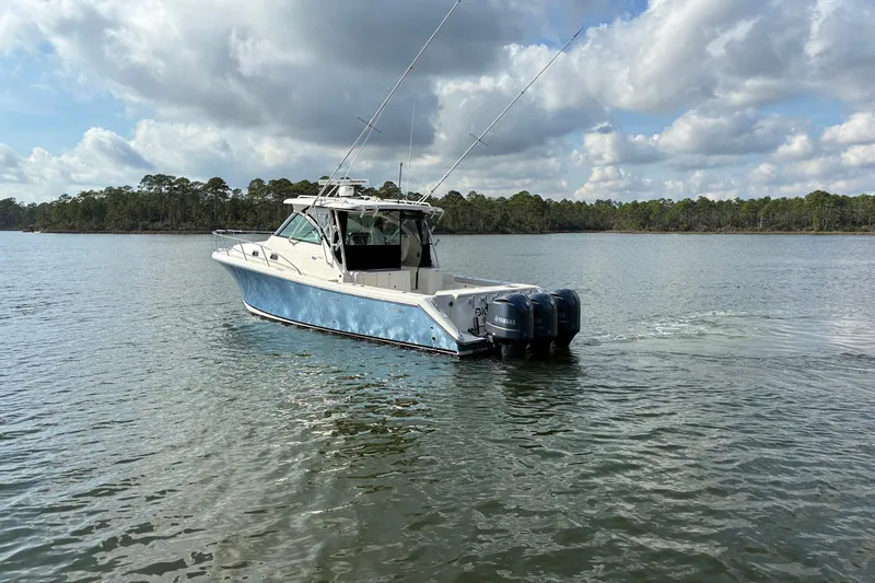 Slide: The Image of 2011 Pursuit OS 375 Offshore boat cruising on a calm lake under a cloudy sky. - 4