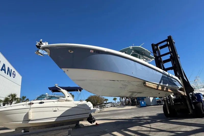 Slide: The Image of 2008 Everglades 350 Center Console boat on forklift at marina, clear blue sky. - 10